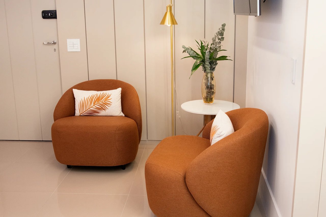 Sala de espera da Clínica La Vena com poltronas terracota e iluminação suave